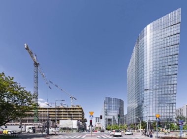 Gökdelen, gökdelen, ofis binası. Güneşli bulutsuz hava. Harmony, düz çizgiler. Şehir trafiği, kavşak