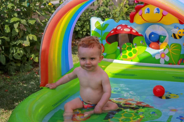 快乐的蹒跚学步的孩子在我家花园的游泳池里玩耍 — 图库照片