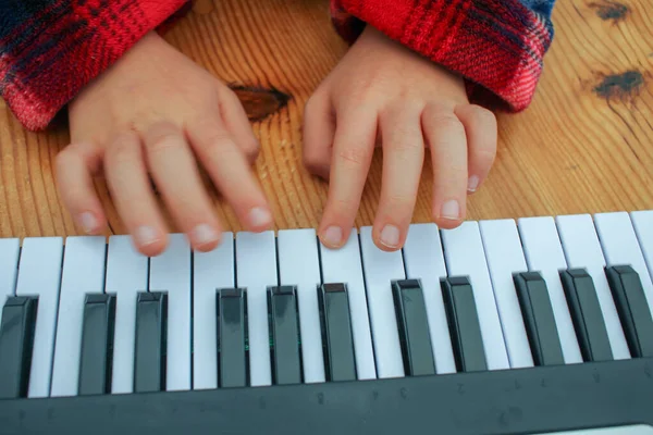 a boy playing a toy piano at home