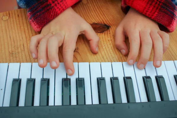 learning to play piano at home in a toy keyboard
