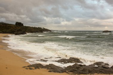 cloudy sky and waves in a beach in the Cantabrian coast