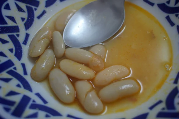 stock image some beans from a fabada and a spoon in a dish