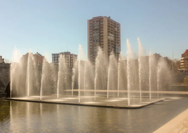 fountains in river Manzanares in Madrid, the capital of Spain, with a building behind