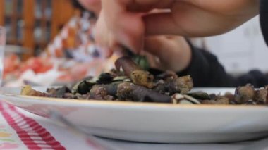 Çocuk elleriyle midye yiyor.
