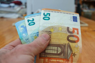 Malların parasını ödemek için sol elimde avroluk banknotlar var.