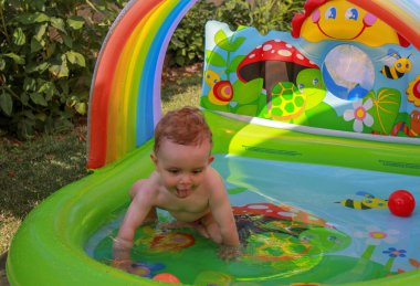 Bebek bahçedeki havuzda eğleniyor.