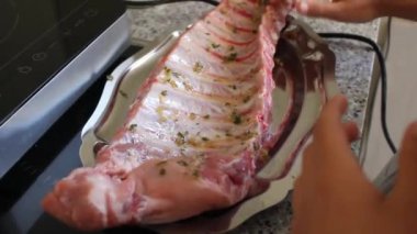 Genç çocuk domuz pirzolası marine ediyor.