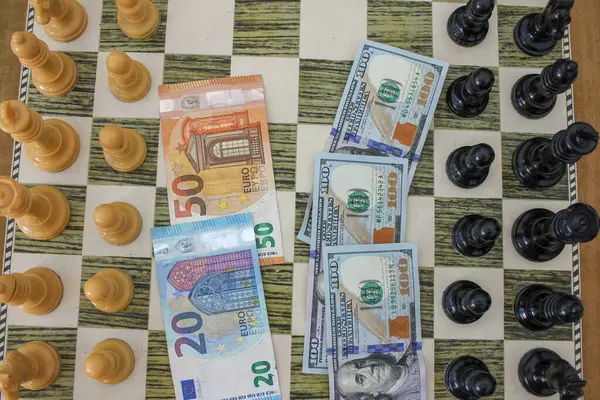 Dolar ve euro banknotları satranç tahtasında bir savaş veriyor. Para savaşı.