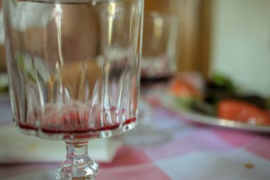 Yemekten sonra masada boş bir kadeh kırmızı şarap.