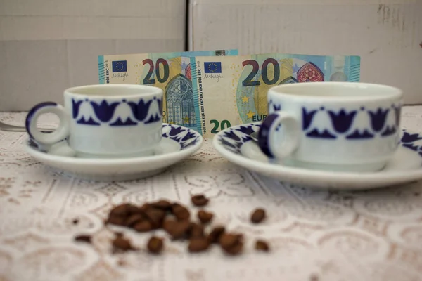 cups of coffee, grains of coffee and euro bills. Concept, the increase in the price of coffee