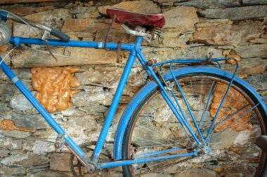 Rustik Cazibe: Antika Bisiklet Taş Arkaplanda Askıya Alındı