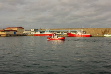 Burela, İspanya; 10 12 2023: İspanya 'nın Burela limanında bulutlu bir gökyüzünün altında bazı gemiler