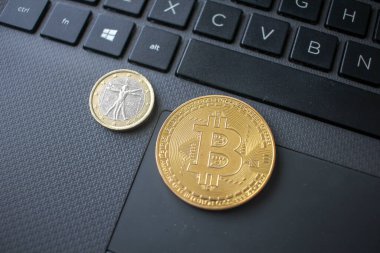 bir bitcoin ve bir euro dizüstü bilgisayarda klavyede