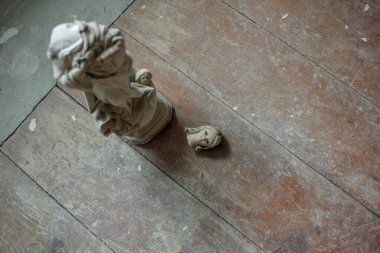 small and broken statue of a virgin found in an old house clipart