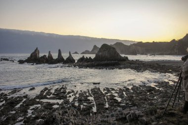 İspanya 'nın Asturias kentindeki Gueirua plajı, gündoğumu ışıkları altında.