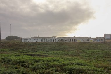 Estaca de Bares, İspanya 'da bulutlu bir gökyüzünün altında terk edilmiş binalar.