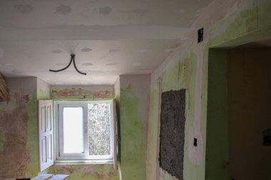 Eski bir evin duvarları ve tavanı boyanmaya hazır.