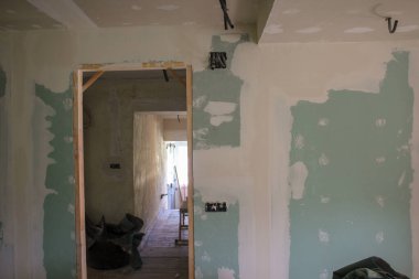 Eski bir ev duvarları ve tavan daha sonra boyanmak üzere tamir ediliyor.