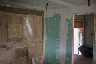 Eski bir evde, beyaza boyamak için yeşil bir duvar hazırlıyorum.