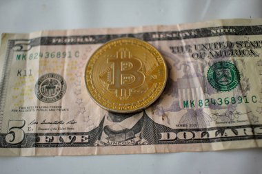 Beş dolarlık banknotla Lincoln 'ün yüzünde bir bitcoin.