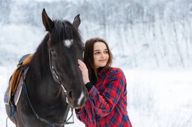 Ekoseli siyah beyaz gömlekli güzel bir esmer kız yürüyor.