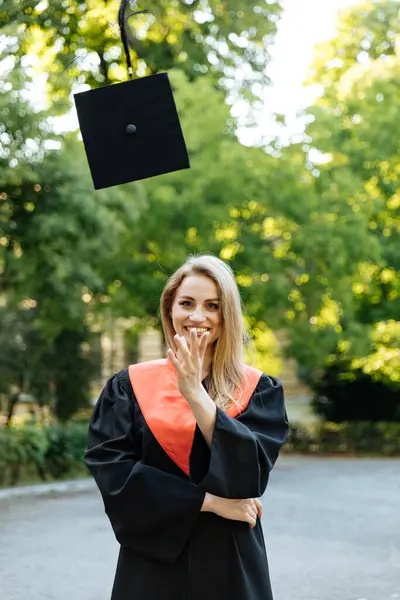 Beautiful university graduate in a black gown. The happy student successfully completed university and obtained a master\'s degree.
