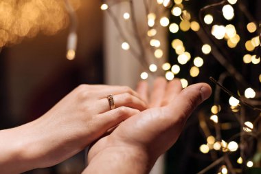 Elinde alyans tutan bir insan.