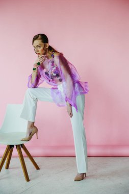 Pembe ve beyaz ipek elbiseli genç kadın..