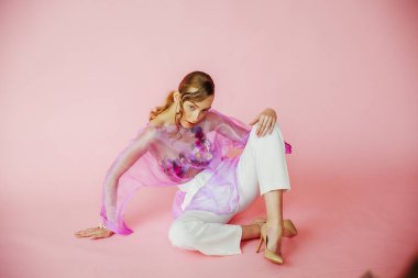 Stüdyoda poz veren pembe elbiseli güzel kadın.