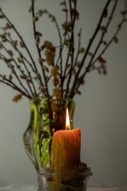 Masada yanan mum ve çiçekler, yakın plan.