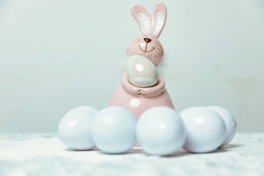 Paskalya yumurtası ve tavşanı pembe arka planda fotokopi alanı ile