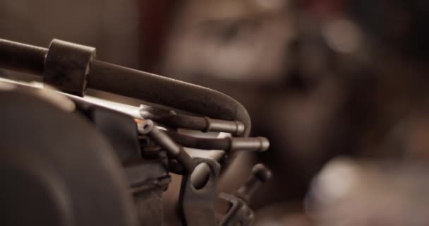 プロの修理ワークショップでワークベンチに置かれた車のモーターの詳細のラックフォーカスハンドヘルドショット — ストック動画