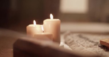 Evdeki meditasyon sırasında yanan mumların yanında aromatik duman yayan kereste tütsü kutusunun el kamerası görüntüsü.