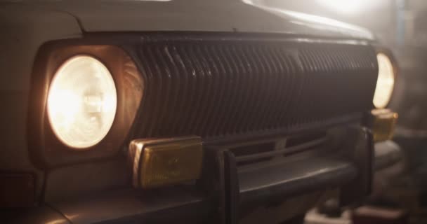 Closeup Handheld Shot Vintage Vehicle Glowing Headlights Parked Repair Workshop — Stock Video