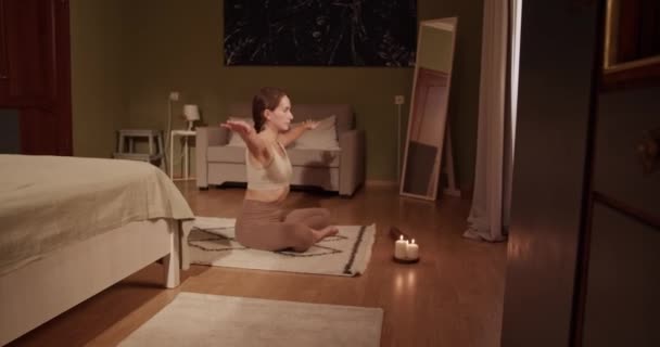 在家庭瑜伽课上冥想时 手持女性交叉腿坐在靠近芬芳蜡烛的垫子上做鹰臂的照片 — 图库视频影像