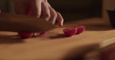 Evdeki sağlıklı salatayı hazırlarken keskin bıçakla doğranmış taze domatesleri doğrayan kimliği belirsiz kadının el kamerası görüntüsü.