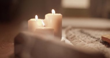 Evdeki meditasyon sırasında yanan mumların yanında aromatik duman yayan kereste tütsü kutusunun el kamerası görüntüsü.