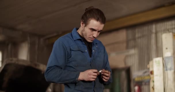 Garajda Çalışırken Genç Bir Adamın Bujiyi Incelerken Elde Çekilmiş Fotoğrafı — Stok video