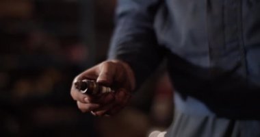 Garajda çalışırken iş kıyafetli bir gencin bujiyi kontrol ederken çekilen el kamerası görüntülerini yukarı aşağı eğ.