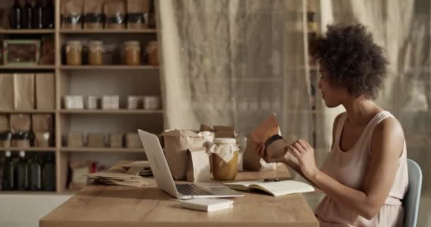 머리를 유기농 제품들 테이블에 앉아서 친환경 가게에서 노트북으로 일하는 운송에 — 비디오