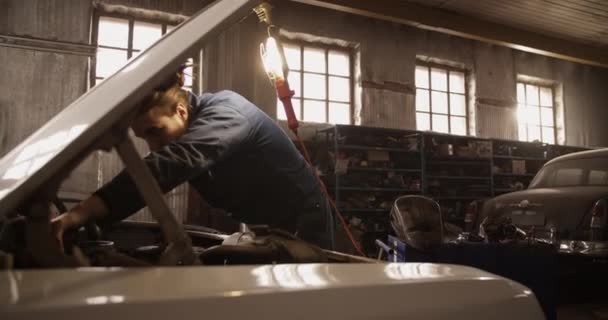 Erkek Teknisyenin Gündüz Vakti Güneşli Garajda Çalışırken Aracın Motorunu Sökmek — Stok video