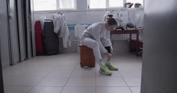 Spor Salonunun Soyunma Odasında Taburede Oturup Eskrim Antrenmanına Hazırlanırken Üniformalı — Stok video