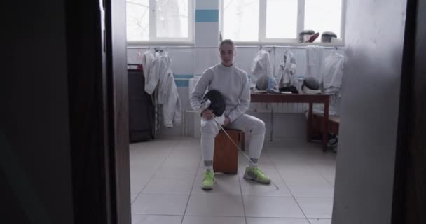 Ręczne Ujęcie Sportowca Mundurze Folią Maską Siedzącego Ławce Drzwiami Garderoby — Wideo stockowe