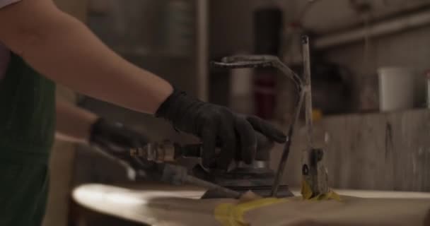 手工拍摄的匿名女技师白天在日光浴车库工作时 带着砂光机和砂盘走人的照片 — 图库视频影像