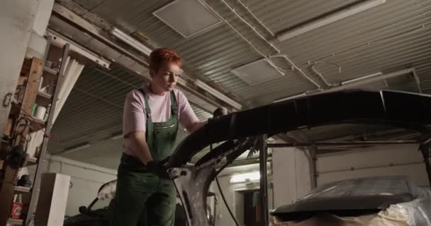 페인트 작업장에서 일하는 사포질 기계를 사용하여 머리를 일하는 여성의 — 비디오