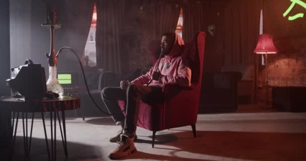 Full Length Casual Millennial Man Sitting Armchair Smoking Hookah Drinking — Video