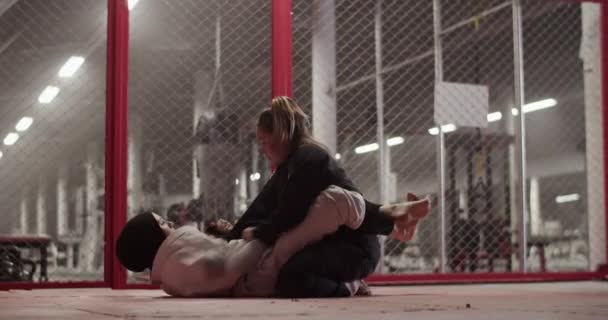Muslim Female Fighter Performing Triangle Choke While Lying Floor Fighting — стокове відео