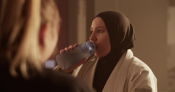Handheld Shot Muslim Woman Hijab Sipping Water Bottle Talking Supportive — Stockvideo