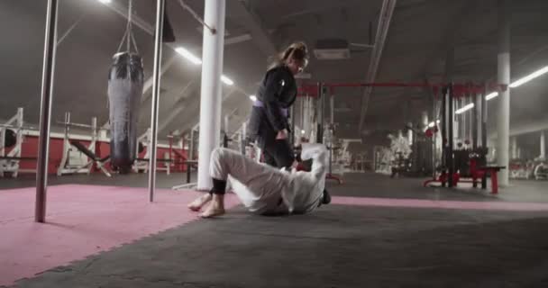 Слідкуючий Постріл Мусульманського Бійця Лежить Підлозі Відштовхується Від Жіночого Тренера — стокове відео