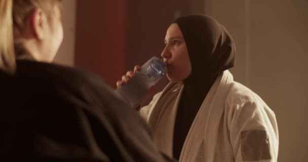 Handheld Shot Muslim Woman Hijab Sipping Water Bottle Talking Supportive — 图库视频影像